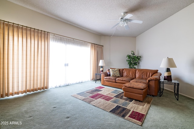 carpeted living area featuring a ceiling fan and a textured ceiling