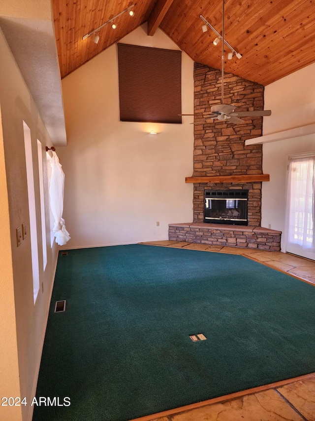 unfurnished living room featuring a stone fireplace, beamed ceiling, high vaulted ceiling, and wood ceiling