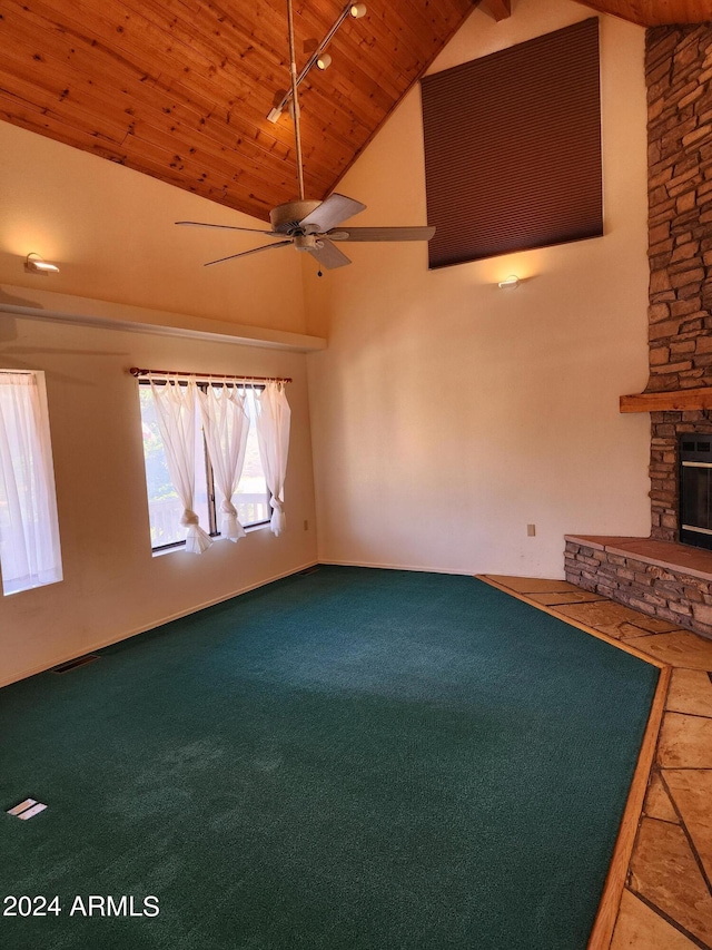 unfurnished living room featuring carpet, high vaulted ceiling, a stone fireplace, ceiling fan, and wood ceiling