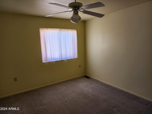 carpeted spare room with ceiling fan