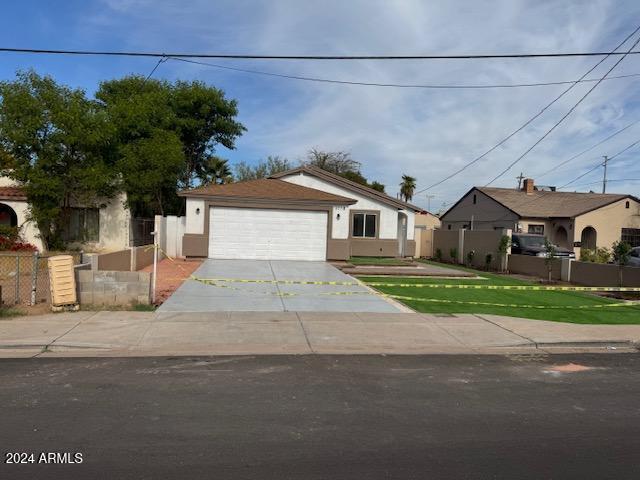 single story home with a garage and a front lawn