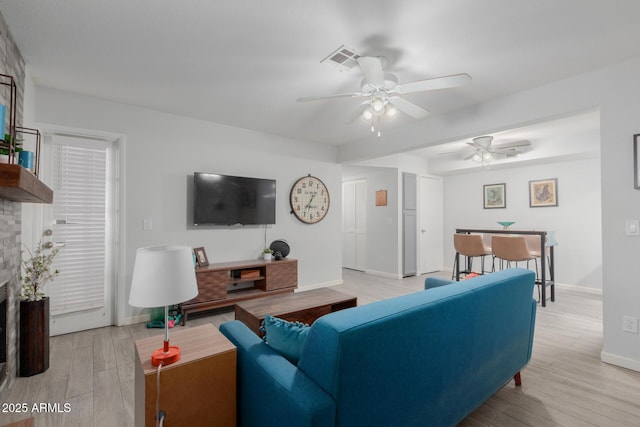 living room with ceiling fan and light hardwood / wood-style flooring