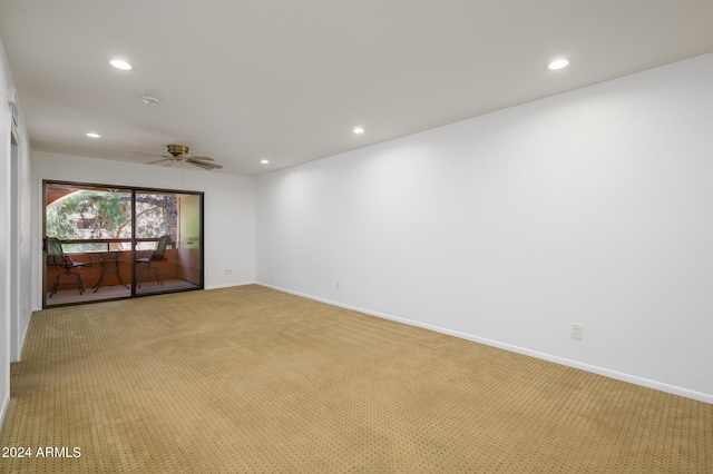 empty room featuring ceiling fan and light colored carpet