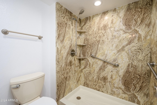 bathroom featuring toilet and a tile shower