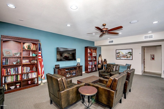 living room featuring a textured ceiling, ceiling fan, and light carpet