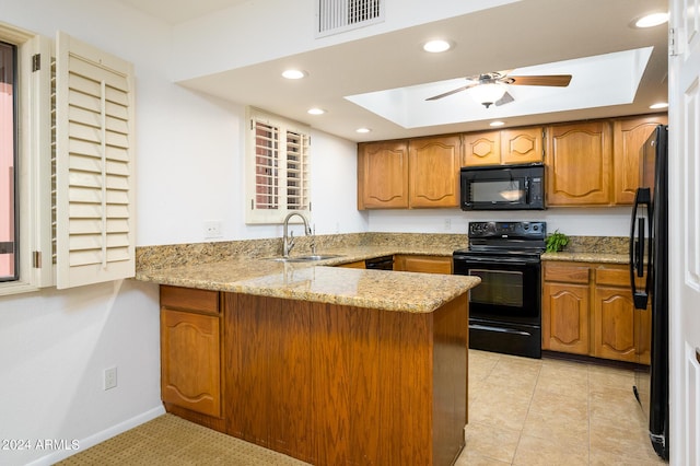 kitchen featuring black appliances, sink, light stone countertops, light tile patterned floors, and kitchen peninsula