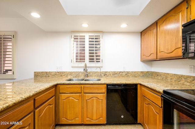 kitchen featuring light stone countertops, sink, and black appliances