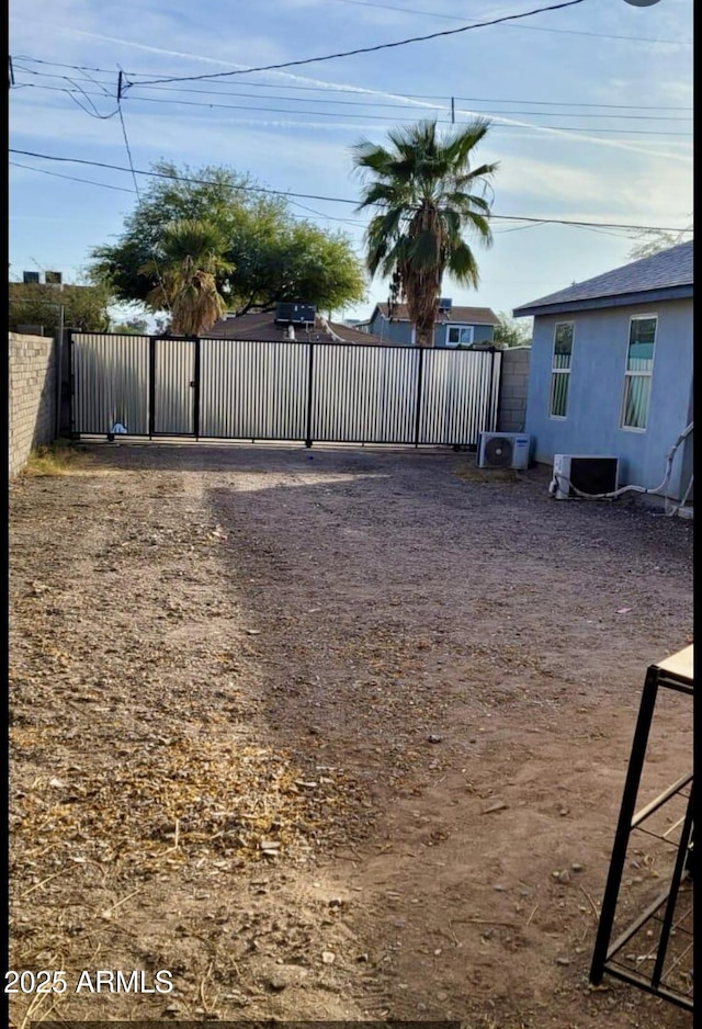 view of yard with central AC unit, a gate, and fence