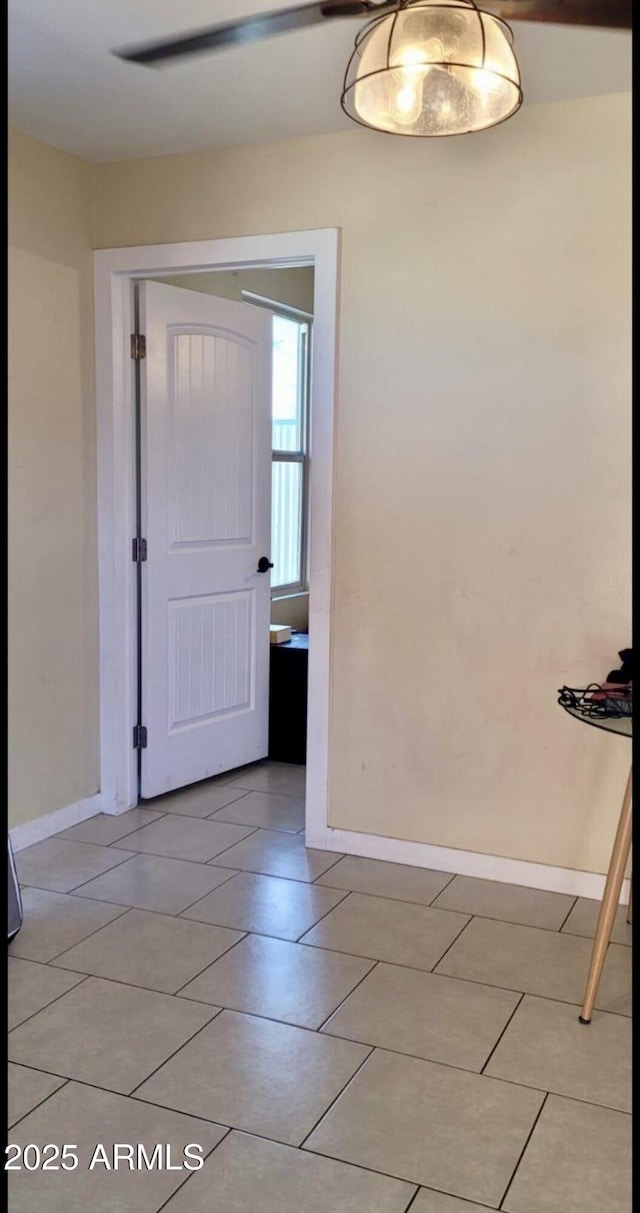 spare room featuring light tile patterned floors and baseboards