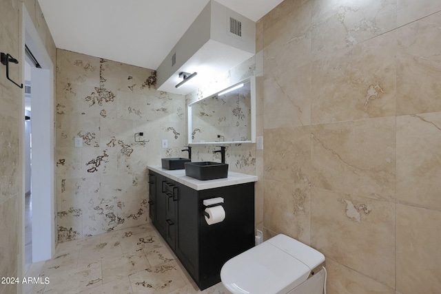 bathroom featuring vanity, tile walls, and toilet