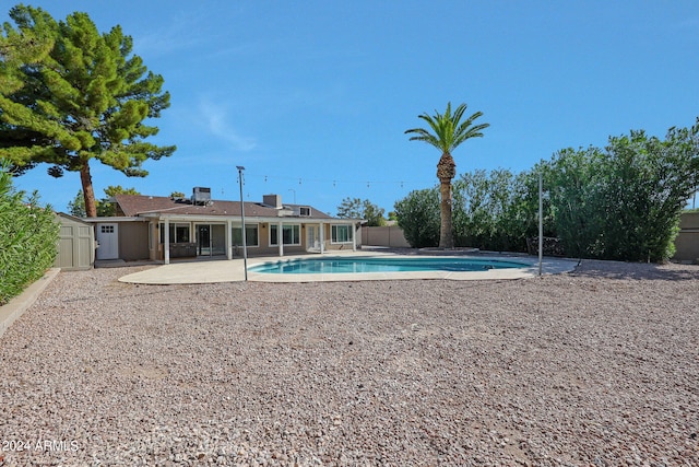 view of pool with a storage shed and a patio area