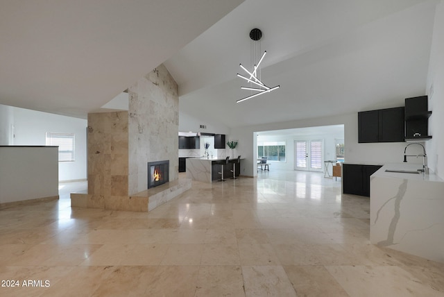 unfurnished living room with vaulted ceiling, a premium fireplace, and sink