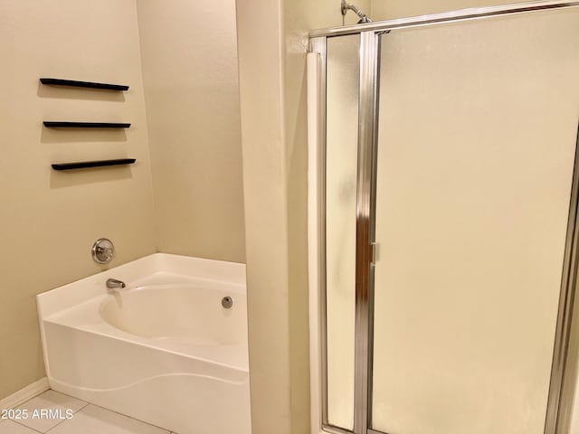 bathroom with a bath, a shower stall, and tile patterned flooring