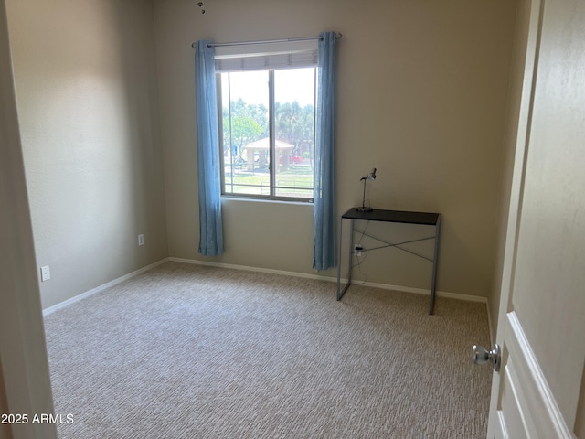 carpeted spare room featuring baseboards