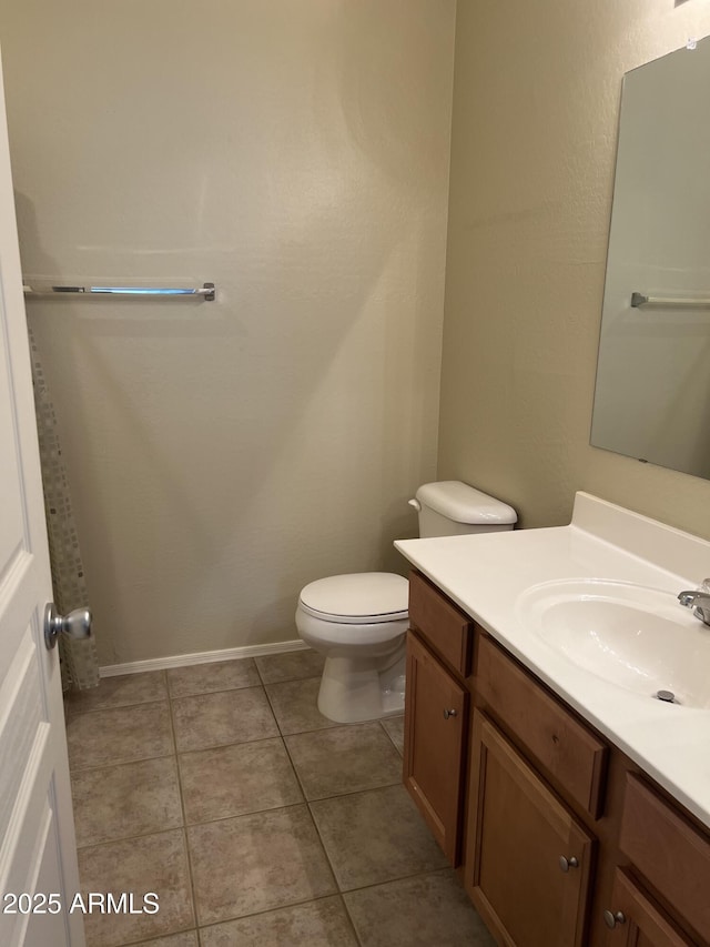 bathroom featuring tile patterned floors, toilet, vanity, and baseboards