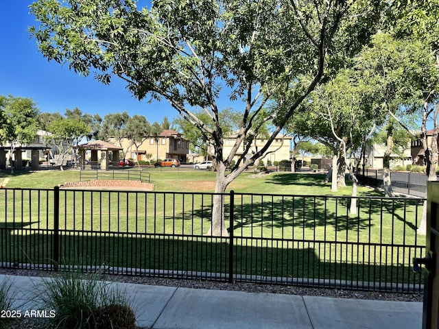 surrounding community featuring a yard, fence, and a residential view