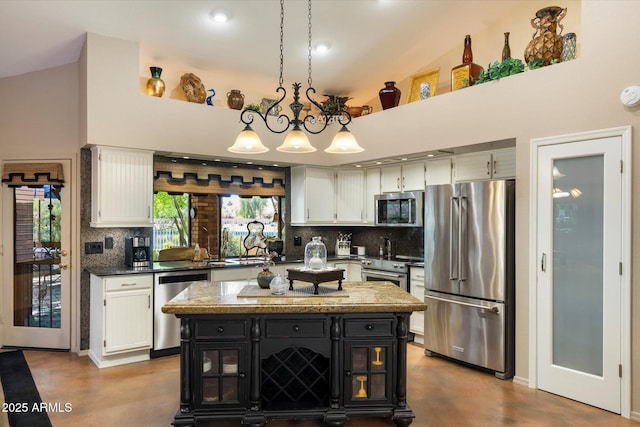 kitchen featuring dark cabinets, backsplash, stainless steel appliances, and white cabinetry