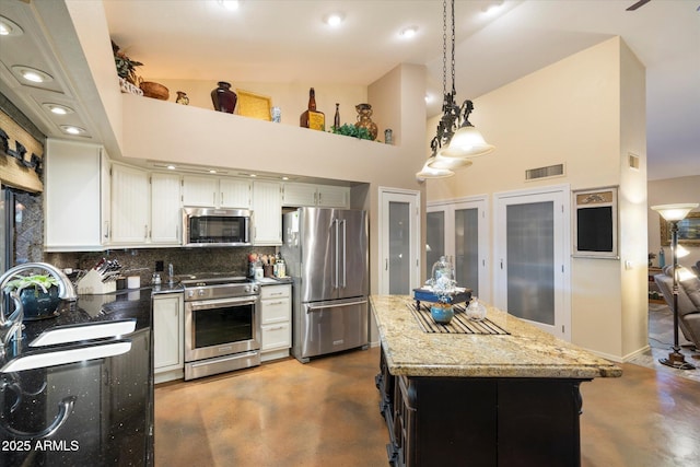 kitchen with decorative backsplash, visible vents, appliances with stainless steel finishes, concrete flooring, and a sink