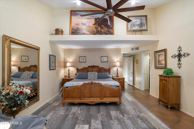bedroom featuring baseboards, visible vents, dark wood finished floors, and a towering ceiling