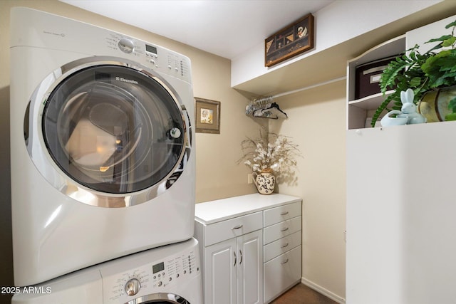 laundry area with stacked washer and dryer and cabinet space