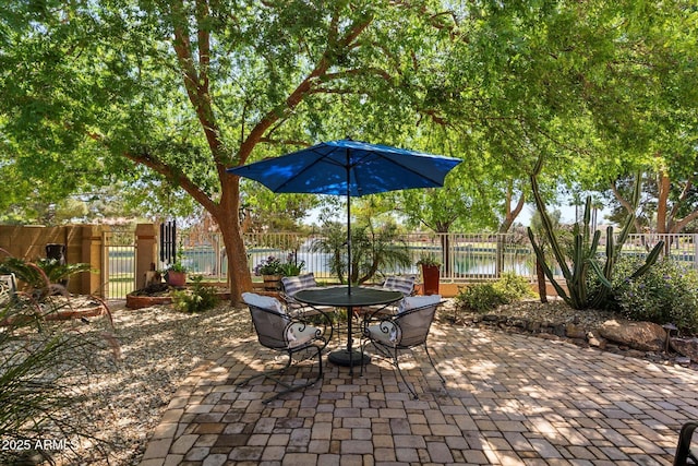 view of patio / terrace with fence private yard, outdoor dining area, and a water view