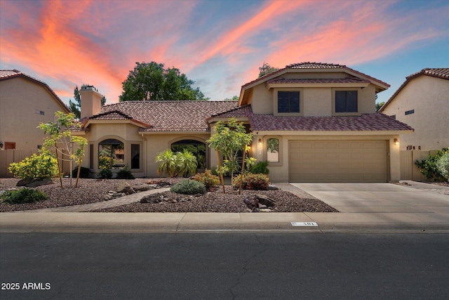 mediterranean / spanish-style house featuring fence, a tile roof, stucco siding, a chimney, and concrete driveway