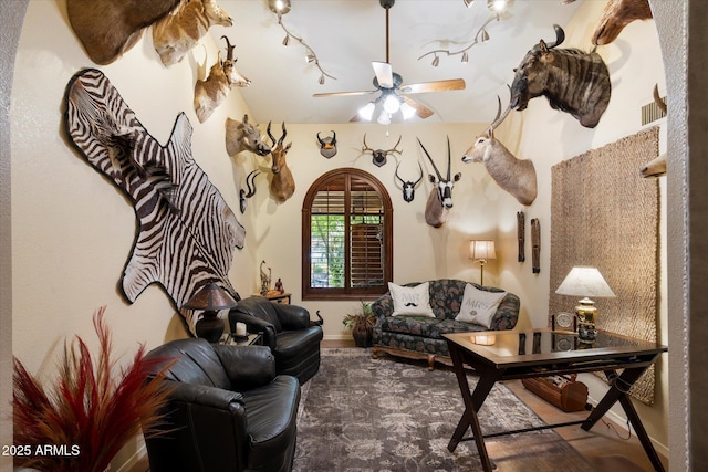 living room featuring baseboards and ceiling fan