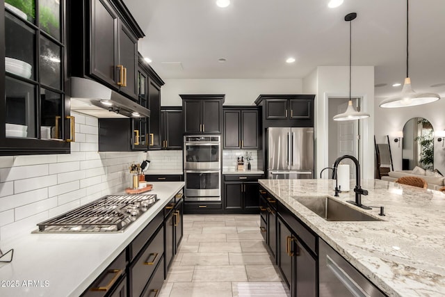 1931 E Aster Pl, Chandler, AZ 85286 - kitchen featuring appliances with stainless steel finishes, under cabinet range hood, backsplash, pendant lighting, and dark cabinets