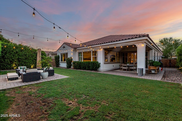 1931 E Aster Pl, Chandler, AZ 85286 - back of property at dusk featuring an outdoor hangout area, a patio area, a tiled roof, and stucco siding