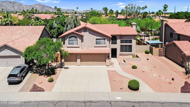 view of front of house with driveway, stucco siding, a tiled roof, an attached garage, and a residential view