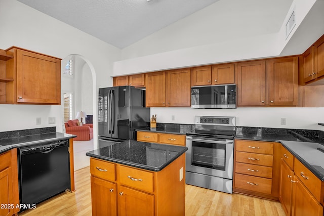 kitchen featuring black appliances, open shelves, light wood finished floors, brown cabinets, and high vaulted ceiling
