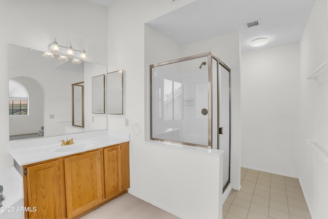 full bathroom with a stall shower, vanity, and tile patterned flooring