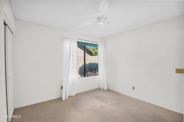 unfurnished bedroom featuring light colored carpet, a closet, a ceiling fan, and a textured ceiling