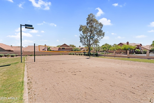 view of community with volleyball court, fence, and a residential view