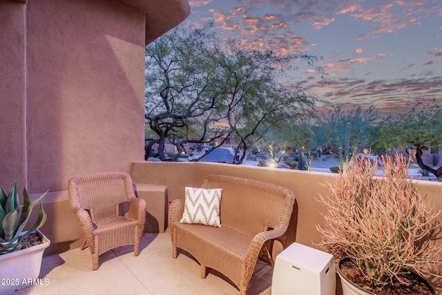 patio terrace at dusk featuring a balcony