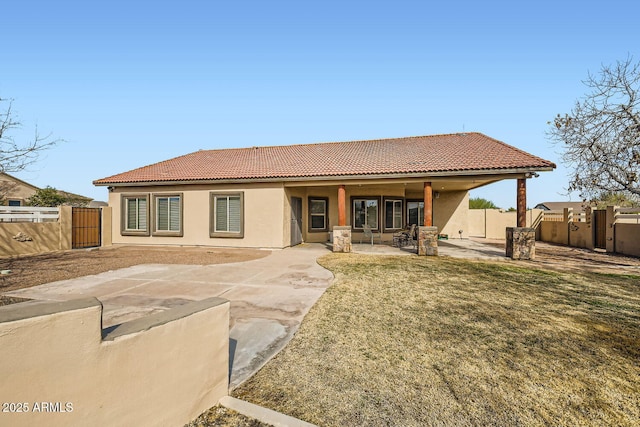 rear view of house with a yard and a patio