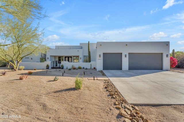 view of front facade with stucco siding, an attached garage, and driveway