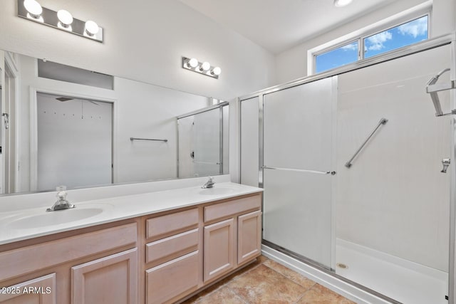 bathroom featuring double vanity, a sink, and a shower with door