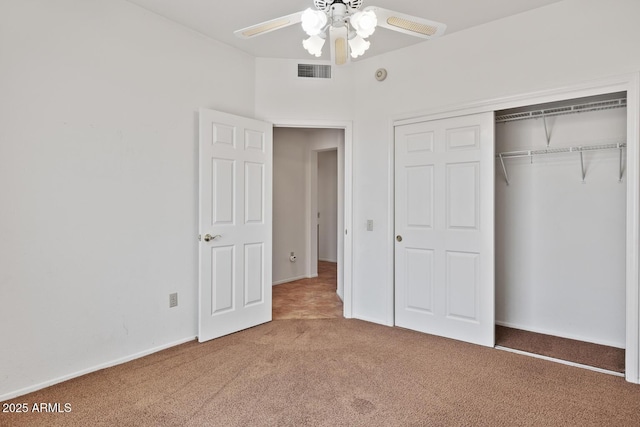 unfurnished bedroom with a ceiling fan, visible vents, carpet floors, baseboards, and a closet