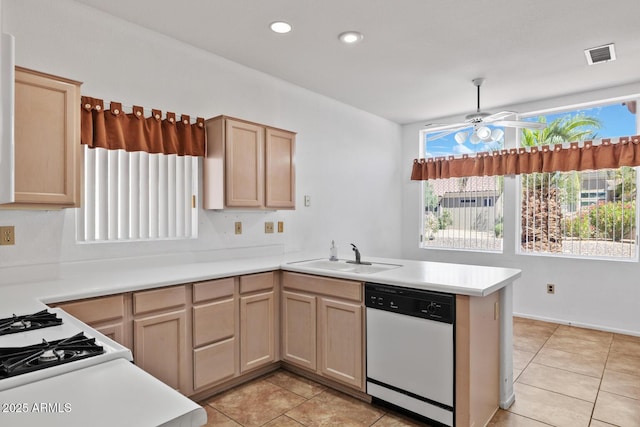 kitchen with visible vents, a peninsula, light brown cabinetry, white appliances, and a sink
