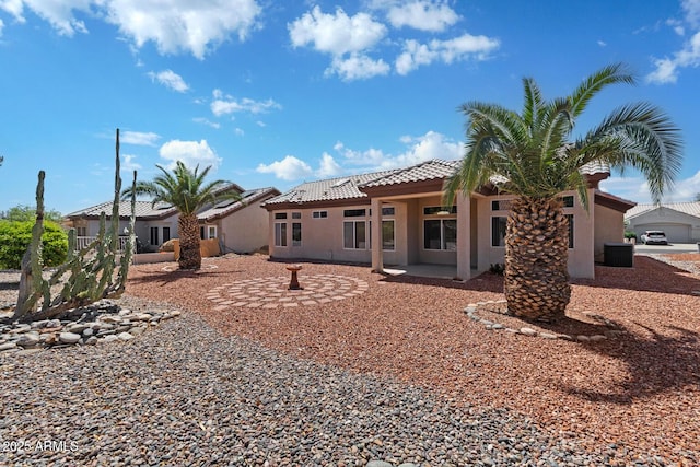 back of property featuring stucco siding, cooling unit, a patio area, and a tile roof