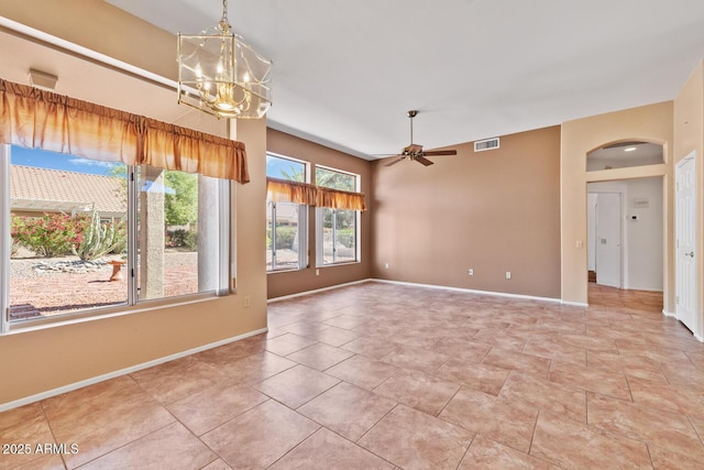 empty room featuring arched walkways, baseboards, visible vents, and ceiling fan with notable chandelier