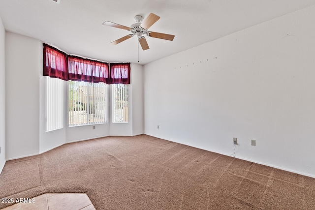 carpeted empty room with a ceiling fan