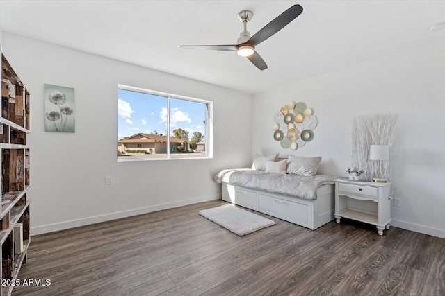 bedroom featuring ceiling fan, baseboards, and wood finished floors