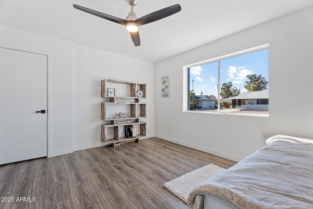 bedroom with ceiling fan, baseboards, and wood finished floors