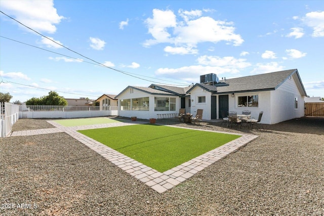 back of house with stucco siding, central AC unit, a fenced backyard, a sunroom, and a patio