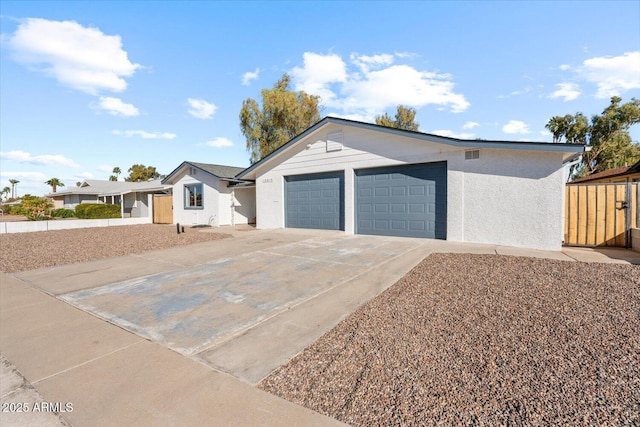 single story home with concrete driveway, an attached garage, and stucco siding