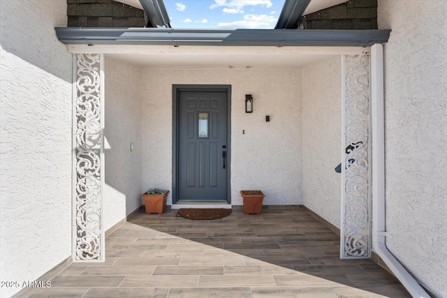 doorway to property featuring stucco siding