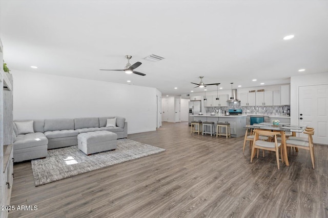 living room with visible vents, wood finished floors, recessed lighting, baseboards, and ceiling fan