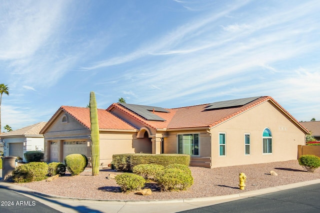 view of front of property with a garage and solar panels